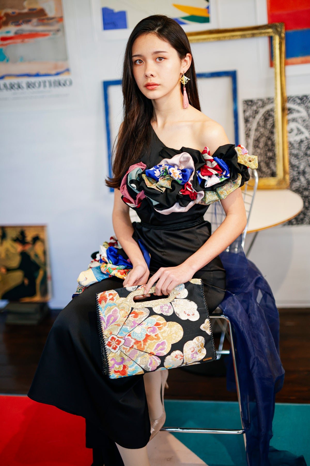 Seated, with the MIKOSHI Bag resting on her lap.