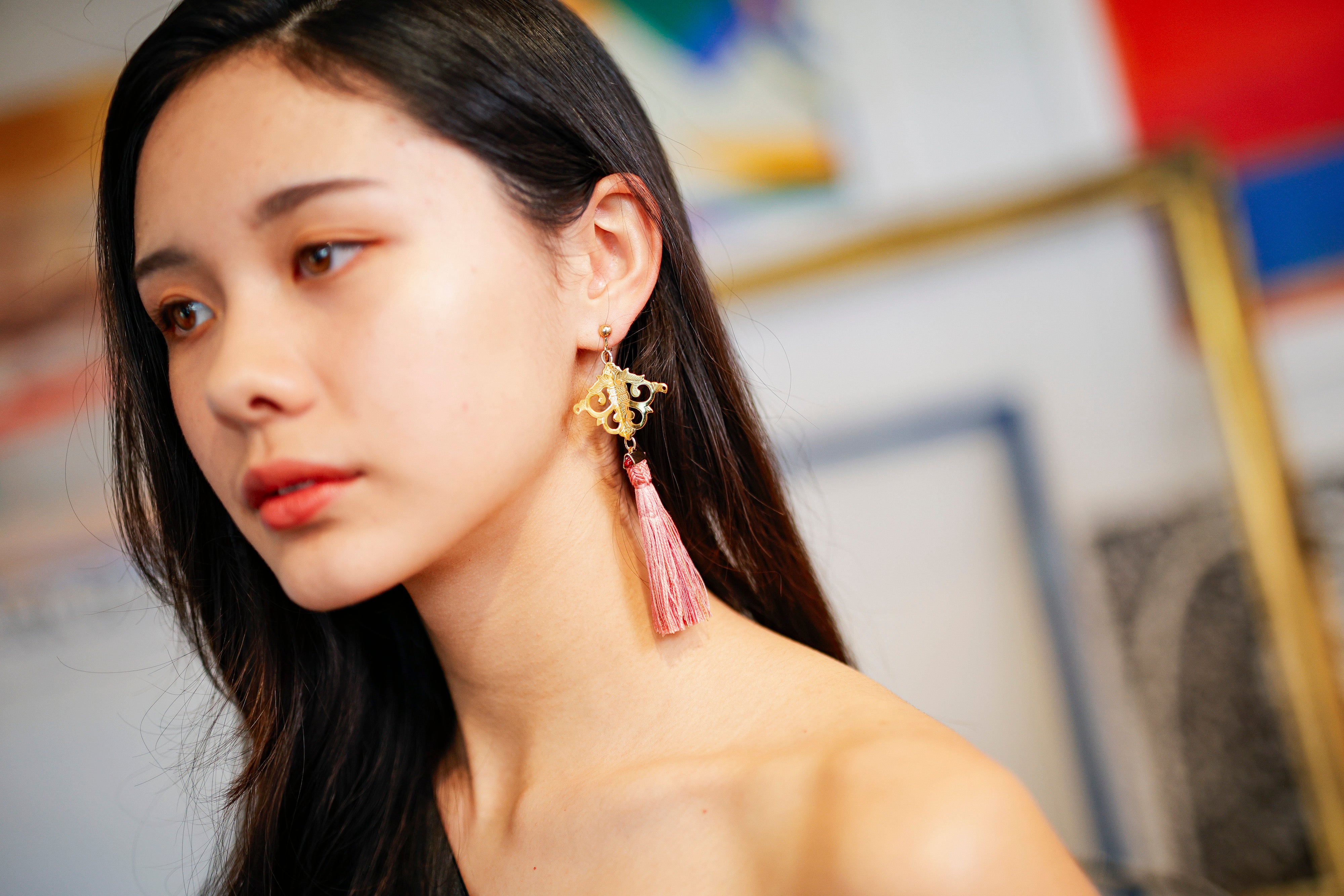 Hana-warabe earring: a pale pink obijime tassel below an engraved arabesque fitting