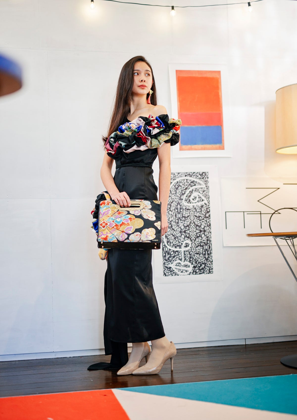 Glancing back, she carries the bag by its engraved handle.