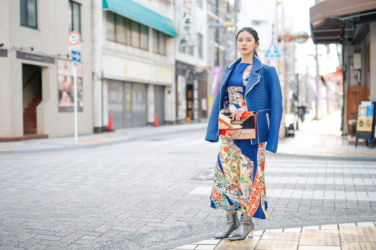 At a crossing, a clutch in vermilion and black obi goes with a blue dress pieced with kimono fabric.