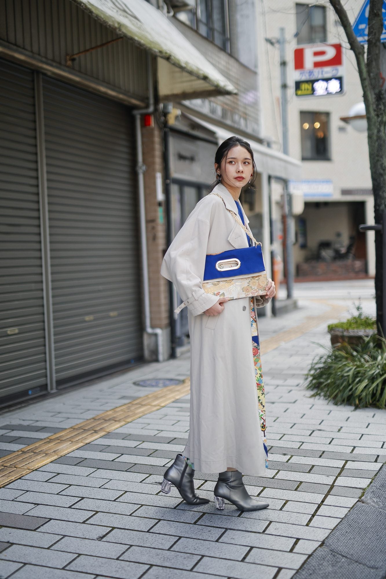 OBI Bag を肩に掛けた全身。トレンチコートの腰の高さに収まる