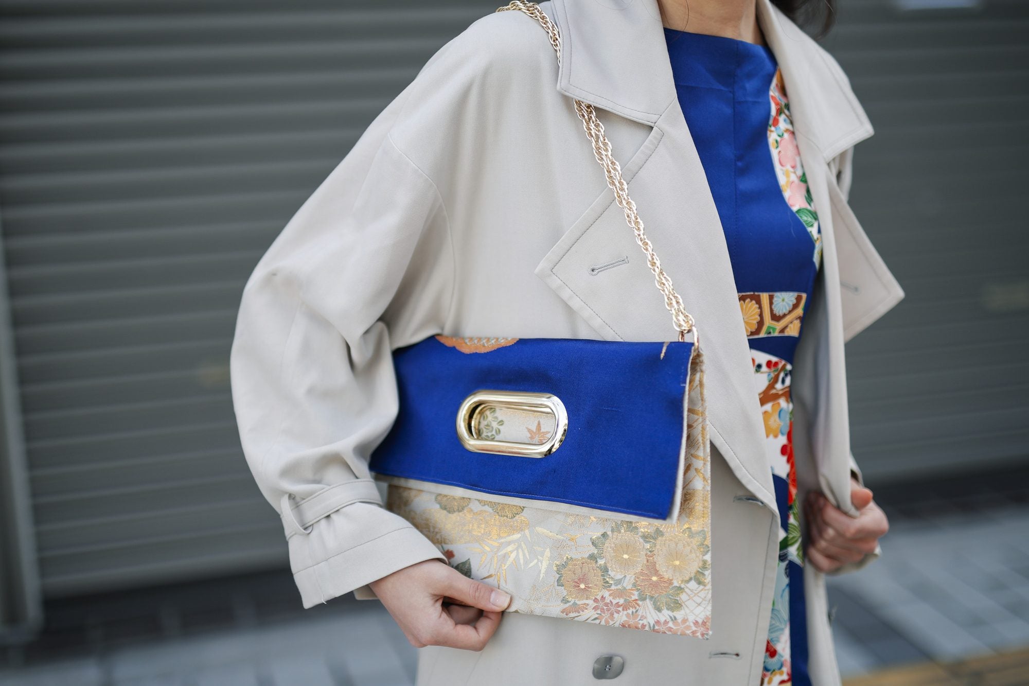 青と金の帯で仕立てた OBI Bag。チェーンを肩に掛け、楕円の金具窓から下の帯の柄がのぞく